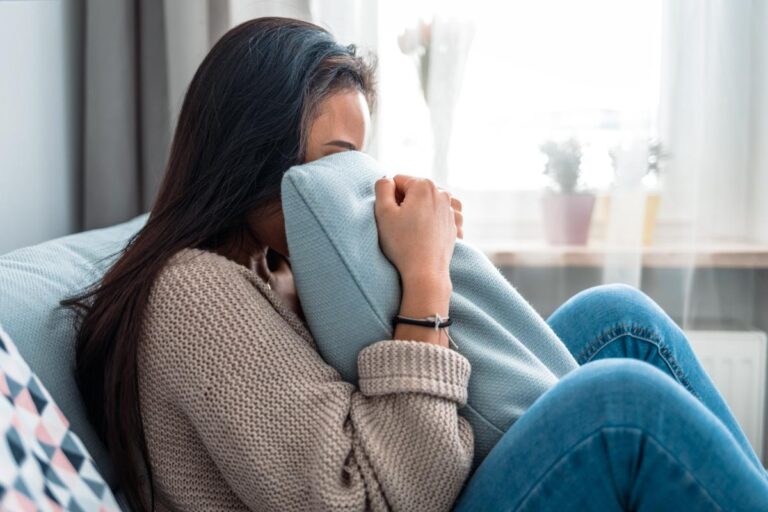 a person experiencing relapse in recovery puts their face in a pillow