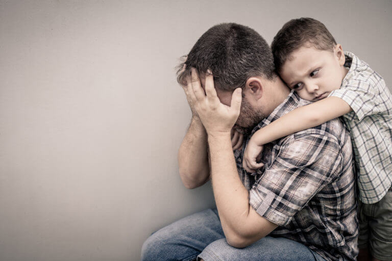 sad son hugging his dad