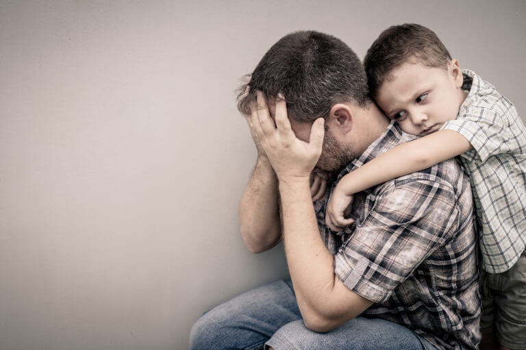 sad son hugging his dad