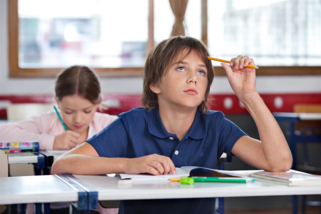 school boy thinking while studying in classs