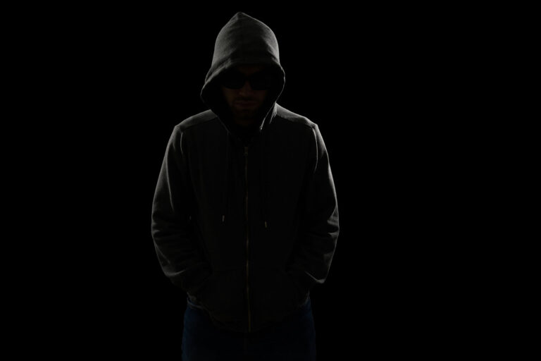 Person in shadows thinking about cutting agents for cocaine