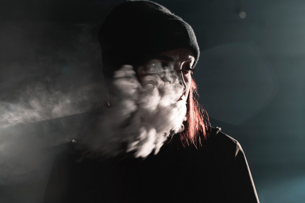 girl smoking and exhaling clouds of smoke