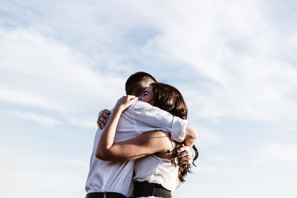 man and woman hugging together