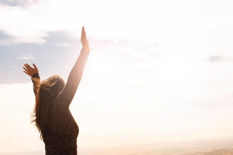 woman raising both hands