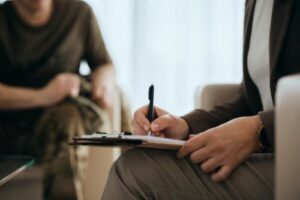 a therapist takes notes during a cocaine addiction treatment session with a patient