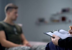 a military member listens to a therapist in a PTSD treatment program