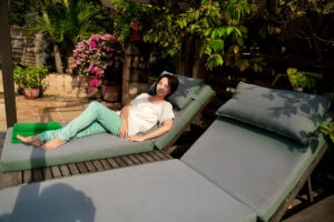 a person lies on a patio chair at a luxury rehab center