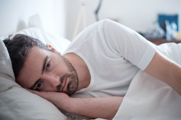 Man lying in bed and thinking about marijuana dependence