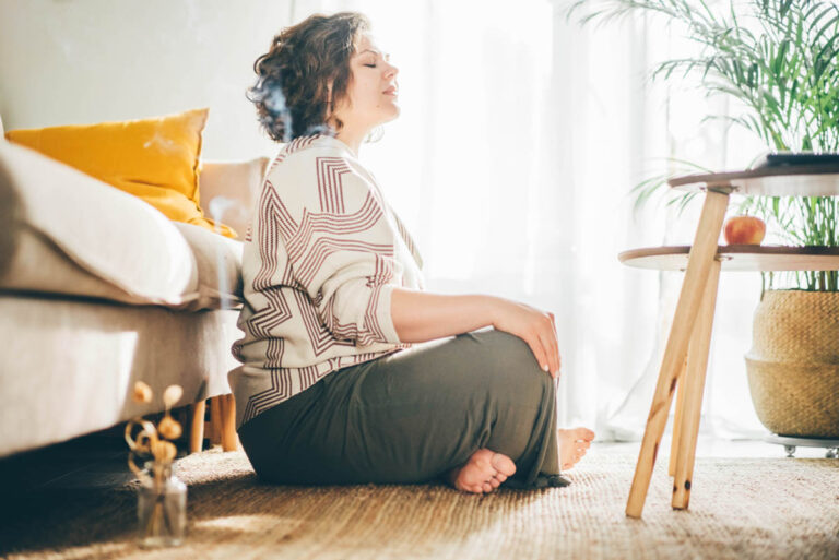 Person sitting on floor and thinking about the holistic approach to addiction treatment